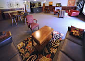 Thumbnail 1 of 13 - A living room with a brown leather couch and a wooden coffee table.