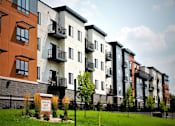 Thumbnail 1 of 18 - A row of modern apartment buildings with balconies and a sign that reads "Revelle Court".