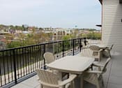 Thumbnail 7 of 18 - A balcony with a table and chairs overlooking a city.