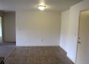 Thumbnail 8 of 18 - A room with a brown tile floor and a white wall.