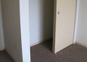 Thumbnail 12 of 18 - A white closet with a door and shelves.