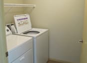 Thumbnail 17 of 18 - A small laundry room with a washer and dryer.