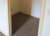Thumbnail 15 of 18 - Empty room with white walls and carpeted floor.