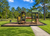 Thumbnail 3 of 4 - A playground with a slide and a wooden structure.