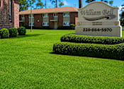 Thumbnail 1 of 4 - A sign for William Bell stands in front of a building and trees.