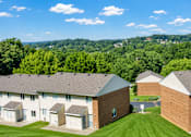 Thumbnail 2 of 4 - A group of houses with a green lawn in front.