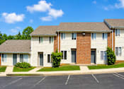Thumbnail 1 of 4 - A row of townhouses with a parking lot in front.