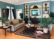 Thumbnail 5 of 11 - a living room with a couch and a table and a television