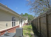 Thumbnail 3 of 11 - the side of a house with a yard and a wooden fence