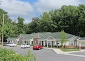 Thumbnail 1 of 11 - a row of houses with cars parked in a parking lot