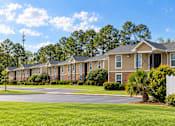 Thumbnail 1 of 11 - A row of houses with a white fence in front.