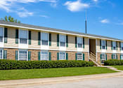 Thumbnail 1 of 2 - A building with a green lawn in front.