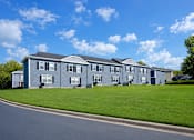 Thumbnail 5 of 5 - A row of houses with a blue sky and clouds in the background.