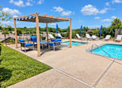 Thumbnail 3 of 10 - A pool area with a pergola and lounge chairs.