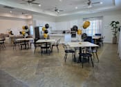 Thumbnail 7 of 15 - A dining room with a table surrounded by chairs and balloons.