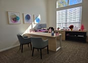 Thumbnail 2 of 15 - A room with a desk and chairs with a painting on the wall.