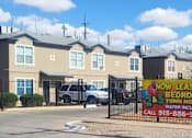 Thumbnail 4 of 7 - A sign in front of a building advertises that 2 and 3 bedroom townhouses are now lease.