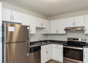 Thumbnail 1 of 25 - Adams Village apartments kitchen with white cabinets and stainless appliances