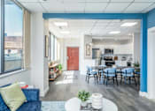 Thumbnail 7 of 23 - a living room and kitchen with a table and chairs