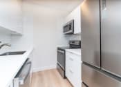 Thumbnail 1 of 23 - Babcock Tower two bedroom kitchen with stainless appliances, bright white finishes, microwave, bifold refridgerator