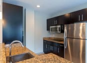Thumbnail 8 of 20 - a kitchen with stainless steel appliances and granite counter tops