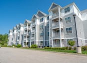 Thumbnail 2 of 28 - a row of apartment buildings with a street in front of them