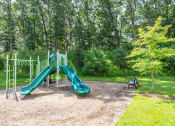 Thumbnail 16 of 28 - a playground with a slide and a bench in a park