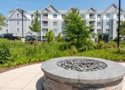 Thumbnail 14 of 28 - a stone fire pit in front of an apartment building