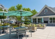 Thumbnail 15 of 28 - a patio with tables chairs and umbrellas outside of a building