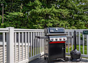 Thumbnail 17 of 39 - A grill is on a deck with a white fence.