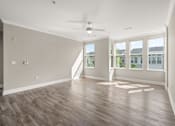 Thumbnail 6 of 35 - A room with a ceiling fan and wooden flooring.