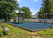 Thumbnail 33 of 39 - A playground with a slide, swings, and a playhouse.