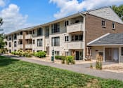 Thumbnail 1 of 39 - Apartment complex with a grassy area in front.