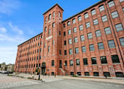 Thumbnail 25 of 29 - A large red brick building with a clock tower.