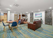 Thumbnail 20 of 29 - A room with a blue and yellow carpet and a brown couch.