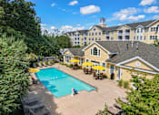 Thumbnail 26 of 27 - A large building with a pool in front of it.