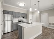 Thumbnail 5 of 35 - A modern kitchen with a large island and stainless steel appliances.