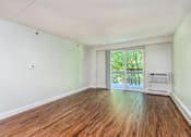 Thumbnail 6 of 28 - an empty living room with wood floors and a door to a balcony