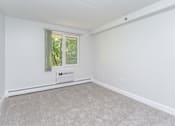 Thumbnail 4 of 28 - an empty living room with white walls and a window