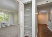 Thumbnail 22 of 28 - an empty living room with an open door to an empty closet