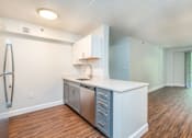 Thumbnail 18 of 28 - an empty kitchen with a counter top and a stainless steel refrigerator