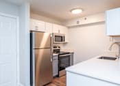 Thumbnail 5 of 28 - a renovated kitchen with stainless steel appliances and white cabinets