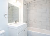 Thumbnail 8 of 28 - a white bathroom with a sink and a mirror