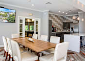 Thumbnail 7 of 26 - A modern dining room with a wooden table and white chairs.