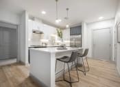 Thumbnail 1 of 25 - a kitchen with a white counter top next to a doorway
