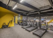 Thumbnail 11 of 25 - a room filled with lots of cardio equipment and weights