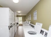 Thumbnail 5 of 23 - A laundry room with rows of washers and dryers.