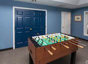 Thumbnail 4 of 23 - A foosball table in a room with blue walls.