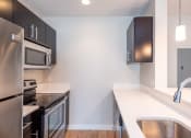 Thumbnail 1 of 20 - Apartment kitchen, dark cabinets, oven, refrigerator, stainless steel