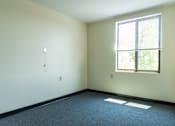 Thumbnail 4 of 12 - A room with a window and a carpeted floor.